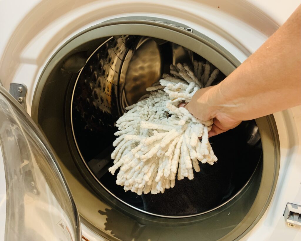 washable mop head being placed in washer
