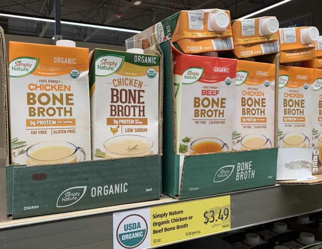 cartons of beef and chicken bone broth in cardboard box on shelf 